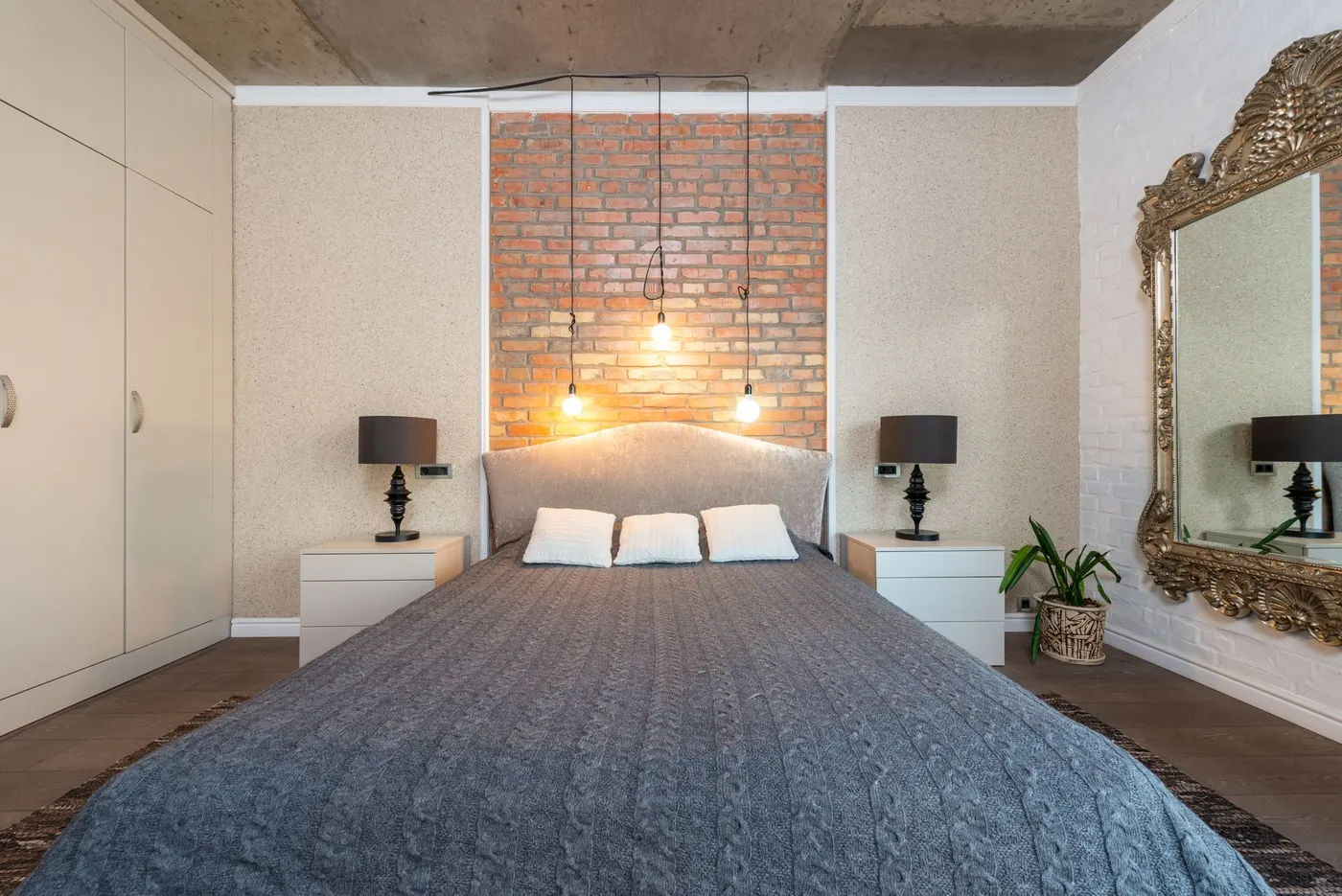 Furnished bedroom with a made bed and bedside lamps