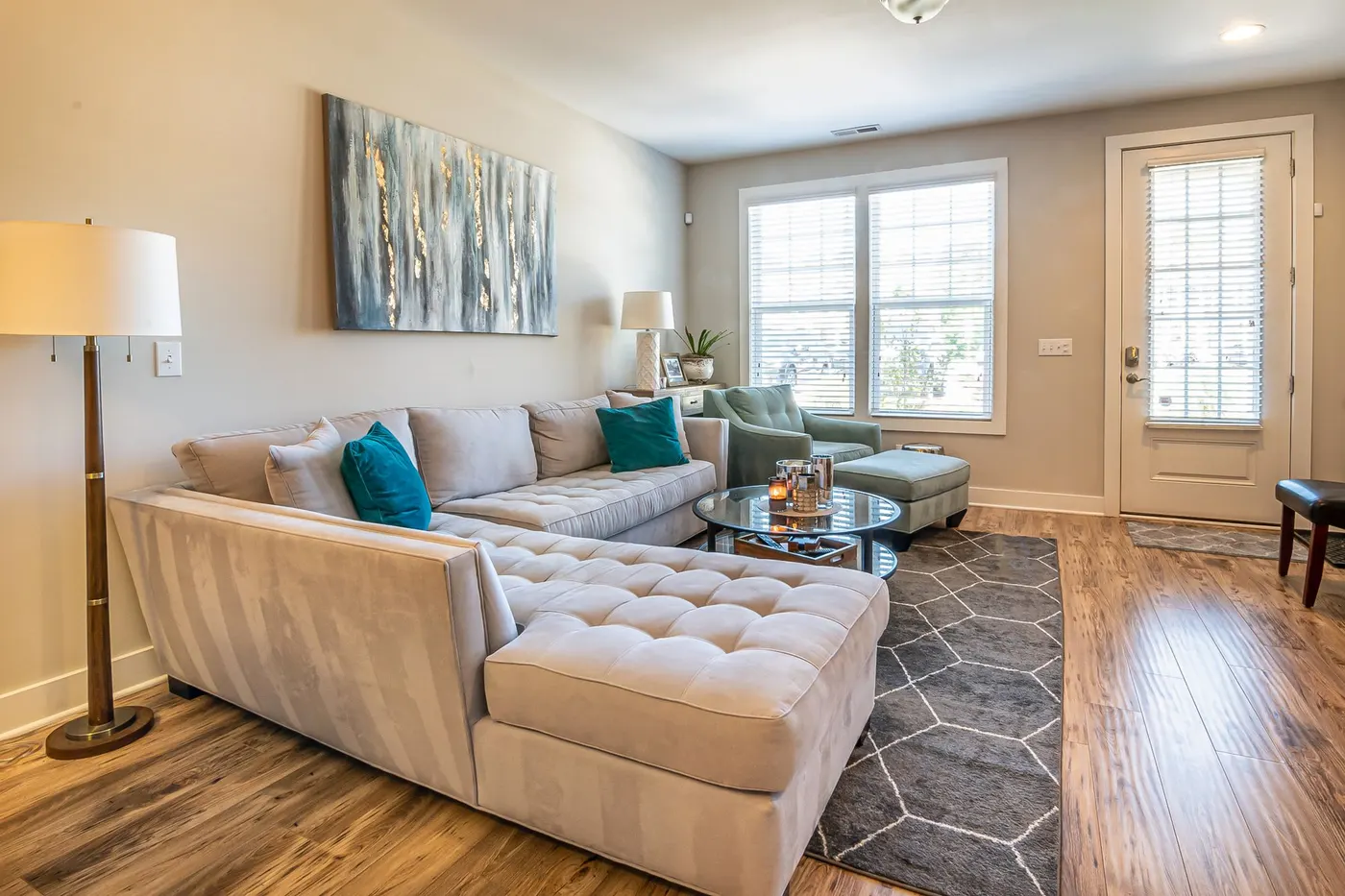 Bright furnished living room with a sectional sofa and large windows