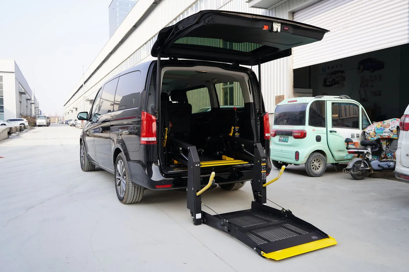Wheelchair-accessible van with its rear lift lowered to the ground, ready for a rider